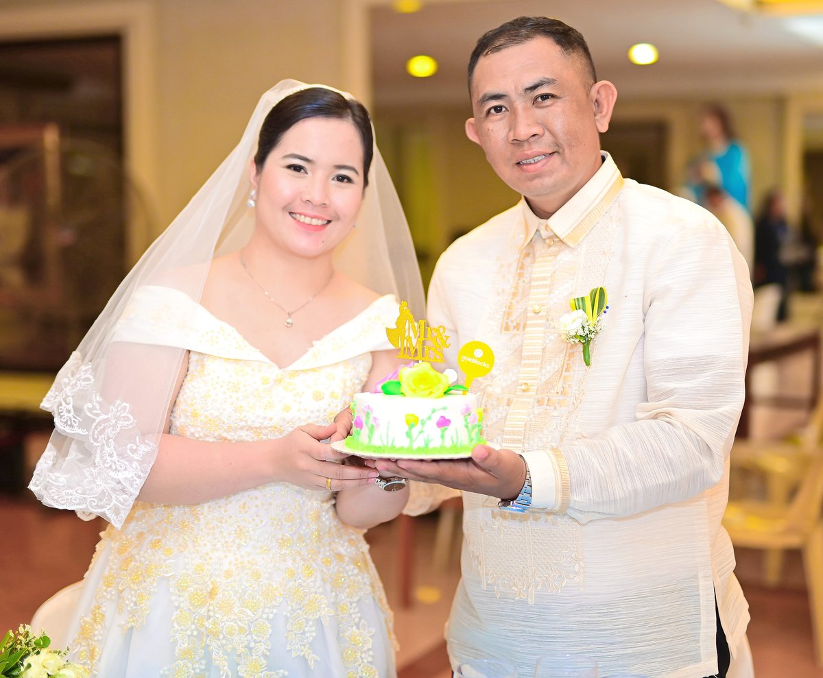 Dolly Grace and RJ Dampog with their beautiful Goldilocks wedding cake, with Goldilocks providing 16 wedding cakes for all the couples.